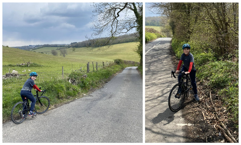 Alex on his road bike about to cycle up a country lane surrounded by green fields.